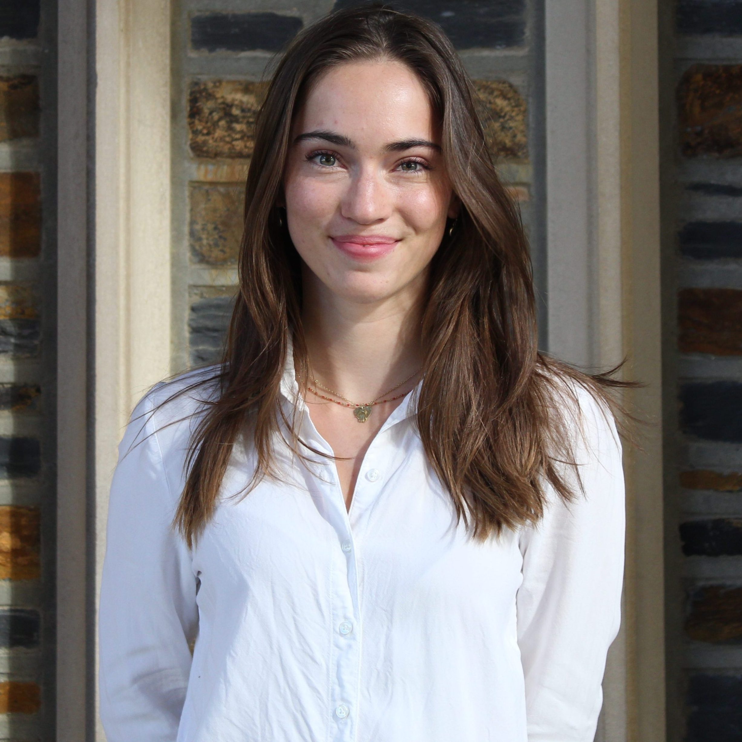 Girl with brown hair smiling at the camera.