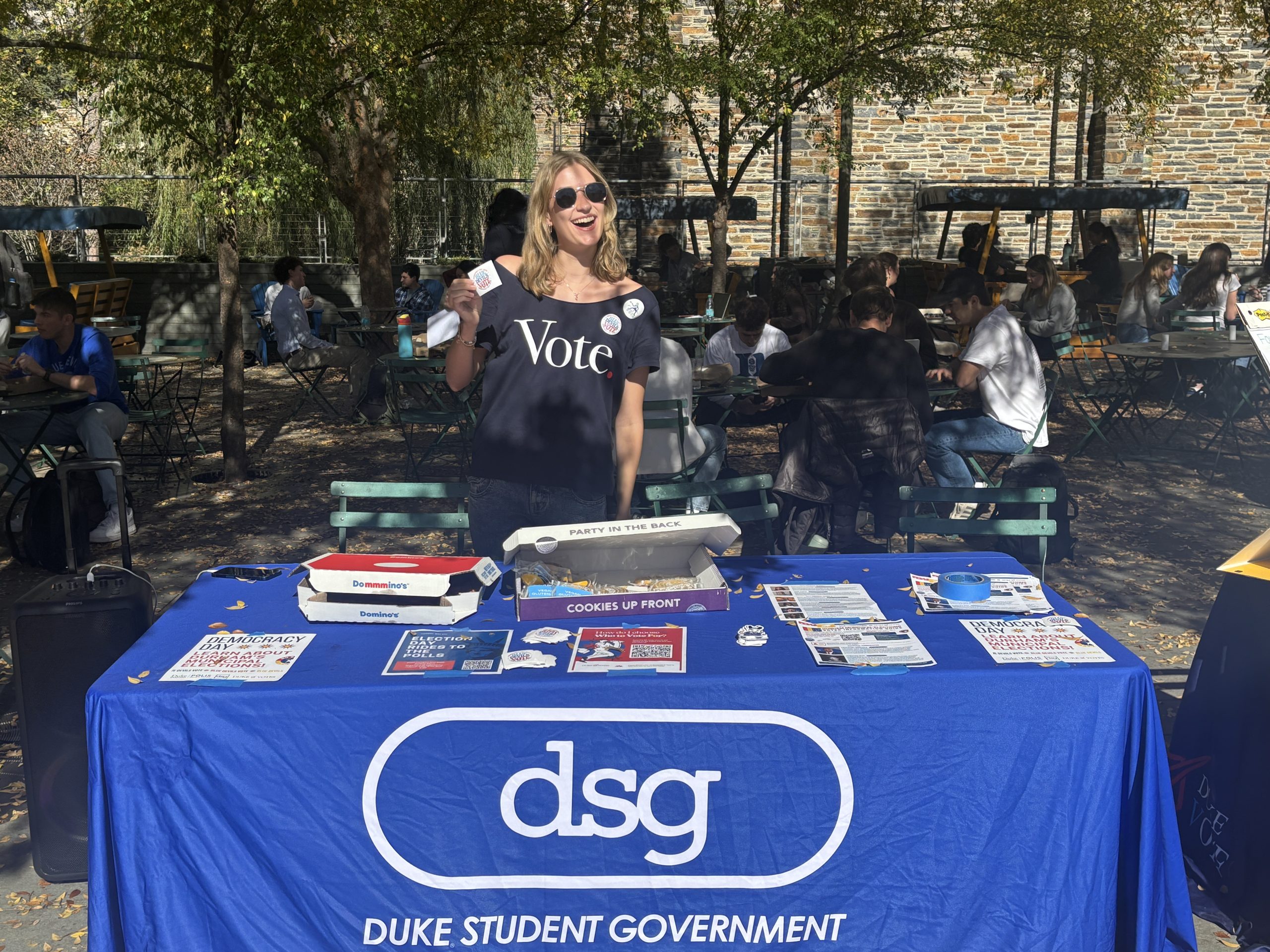 Women smiling holding up a sticker with a group