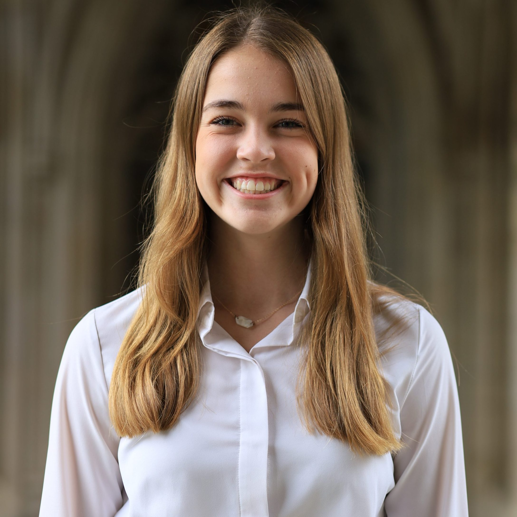 Girl with long blonde hair smiling at the camera